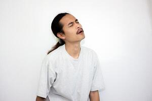 Asian man wearing gray tshirt and long hair making lazy expression after waking up. isolated in white background photo