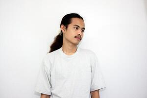 Asian man wearing gray tshirt and long hair making lazy expression after waking up. isolated in white background photo