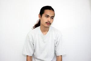 Asian man wearing gray tshirt and long hair making lazy expression after waking up. isolated in white background photo
