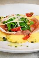 Burrata ravioli with Italian speak and arugula photo