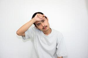 Asian man wearing gray tshirt and long hair making lazy expression after waking up. isolated in white background photo