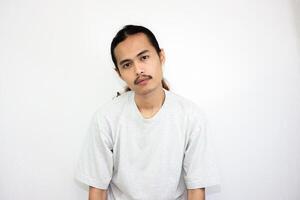 Asian man wearing gray tshirt and long hair making lazy expression after waking up. isolated in white background photo