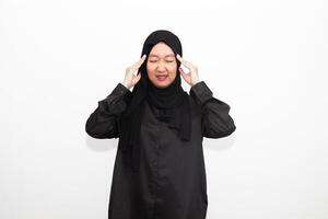 Sad woman in hijab holding hands on head, suffering from headache, suffering from migraine, feeling dizzy, standing on white background. photo