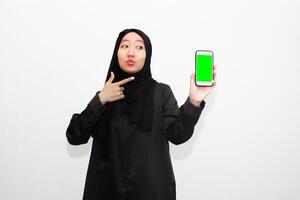 Portrait of young Muslim woman in black shirt and pointing towards the phone. isolated on a white background photo