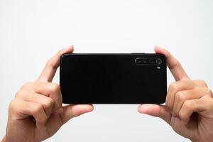 Man's hand holding a smart phone screen view from above. isolated in white background photo