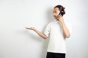 Asian man holding cell phone. pointed to the side and pointed at his cellphone. isolated in white background photo