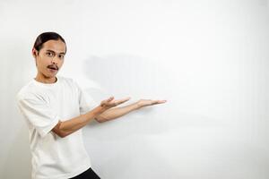 Asian man in white t-shirt pointing to the side. isolated on white studio background. photo