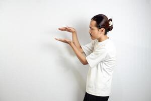 Asian man in white t-shirt pointing to the side. isolated on white studio background. photo