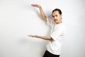 Asian man in white t-shirt pointing to the side. isolated on white studio background. photo
