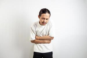 Young Asian man. suffering from severe stomach ache. isolated on white. photo