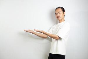Asian man in white t-shirt pointing to the side. isolated on white studio background. photo