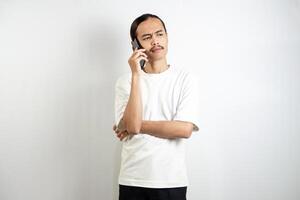 Asian man holding the phone. with a thoughtful expression. isolated in white background photo