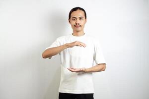 Asian man in white t-shirt pointing forward. isolated on white studio background. photo