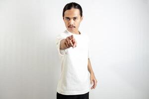 Asian man in white t-shirt pointing forward. isolated on white studio background. photo