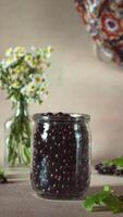 Blackcurrant jam. Stop motion animation. Vertical. Jar is filling with black currant, rotating and turning into jam video