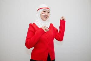 Woman in white hijab wearing red sweater. celebrating Indonesia's independence day. with his hands clenched into fists. isolation on white background. photo