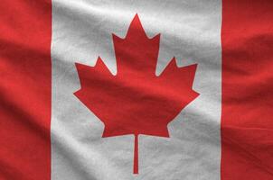 Canada flag depicted on folded wavy fabric of old cloth photo