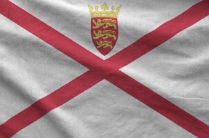 Jersey flag depicted on folded wavy fabric of old cloth photo