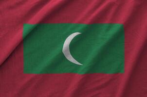 Maldives flag depicted on folded wavy fabric of old cloth photo