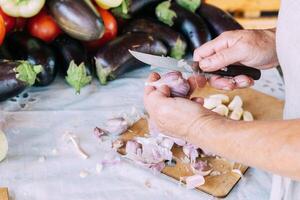 A woman is engaged in the preparation and processing of various fresh farm vegetables photo