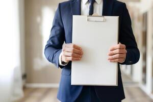 handsome real estate agent holds a folder in hands and shows an empty apartment, empty space for text photo
