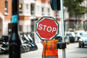Road Construction Worker Holding a Stop Sign to Control Traffic Flow and Ensure Safety at Worksite photo