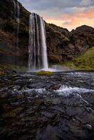 Stunning Seljalandsfoss Waterfall at Sunset, One of Icelands Most Popular and Breathtaking Natural Wonders photo