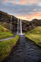 Stunning Seljalandsfoss Waterfall at Sunset, One of Icelands Most Popular and Breathtaking Natural Wonders photo