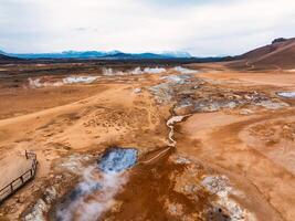 Aerial view of Hverir Geothermal Area in Iceland, capturing boiling mud pools, fumaroles, and the dramatic landscape of this geothermal hotspot near Lake Myvatn. photo