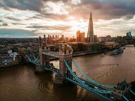 Aerial view to the Beautiful Tower Bridge and skyline of London, UK, during the sunset. photo