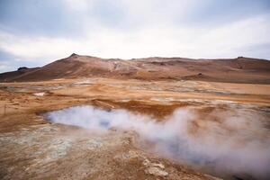 Boiling mudpots in the geothermal area Hverir and cracked ground around. Location geothermal area Hverir, Myvatn region, North part of Iceland photo