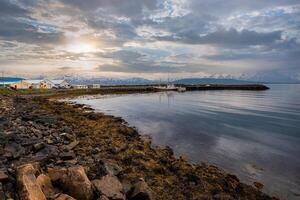 Scenic coastline with fishing boat at sunset in Iceland photo