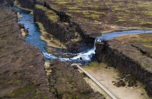 Aerial panorama of Oxarafoss waterfalls in Thingvellir National Park, Iceland, showcasing the Oxara River, the dramatic tectonic plates of America and Eurasia, and the stunning natural landscape. photo