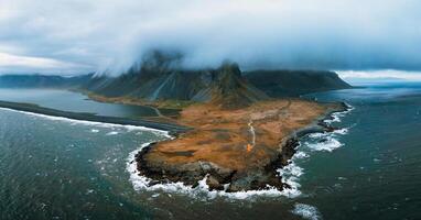 Aerial view of Eystrahorn mountain and coastal landscape on Stokksnes cape in Iceland with dramatic scenery and rugged coastline. photo
