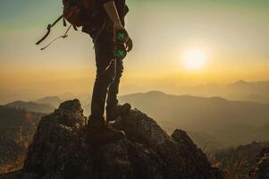 man is standing on a mountain top with a pair of binoculars in his hands photo