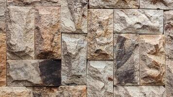 close-up view of a wall constructed with various sizes of rectangular stone blocks photo