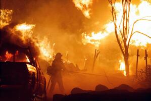 put out a fire, battling the intense flames with a hose and showcasing the bravery and dedication required to manage such a dangerous situation photo