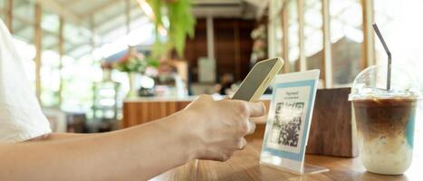 Woman use smartphone to scan QR code to pay in cafe restaurant with a digital payment without cash. Choose menu and order accumulate discount. E wallet, technology, pay online, credit card, bank app. photo