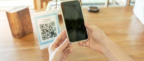 Woman use smartphone to scan QR code for order menu in cafe restaurant with a digital delivery. Choose menu and order accumulate discount. E wallet, technology, pay online, credit card, bank app. photo