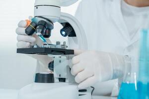 Scientist analyze biochemical samples in advanced scientific laboratory. Medical professional use microscope look microbiological developmental of viral. Biotechnology research in science lab. photo