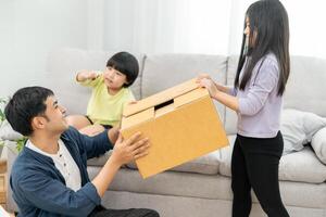 Moving house, relocation. Family smile and play together after move to new home, inside the room was a cardboard box contain personal belongings and furniture. move in the new apartment, condominium photo