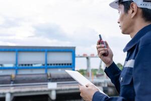 maintenance and inspector. Maintenance engineers are using walky talky to inform the results of inspection of buildings and structures. Irrigation engineers are exploring sluice systems photo