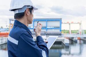 maintenance and inspector. Maintenance engineers are using walky talky to inform the results of inspection of buildings and structures. Irrigation engineers are exploring sluice systems photo