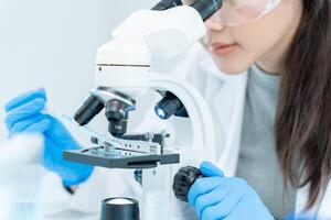 Scientist analyze biochemical samples in advanced scientific laboratory. Medical professional use microscope look microbiological developmental of viral. Biotechnology research in science lab. photo
