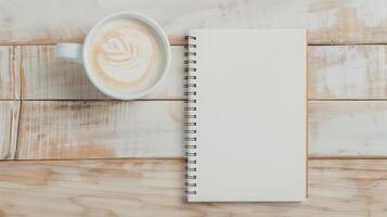 Top View of Latte with Latte Art and Blank Spiral Notebook on Wooden Table for Writing or Drawing in a Creative Workspace or Cafe Setting, Ideal for Design, Planning, and Journaling Concepts photo