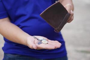 Poor man hold leather wallet with some coins. Concept bad economy, financial crisis, risk on the end of month. Finance management. Pay day. Debt. Broke. Bankrupt. Financial problems. photo