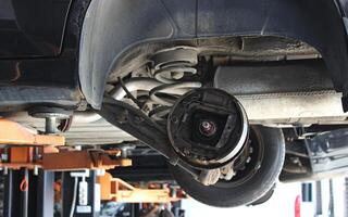 Disassembled brake drum of large SUV on the stand of the lift in the auto service workshop. Brakes inspection and repair photo