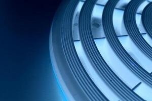 Round platform with concentric pattern illuminated with blue light with copy space photo