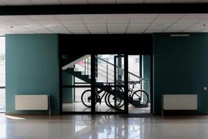 Bicycles in a special place near the stairs at the entrance to the office building. Transportation to get to work in the city. Post delivery by bicycle for office photo