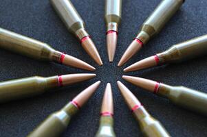 Circle of live ammunition on black silk velvet surface angle view photo